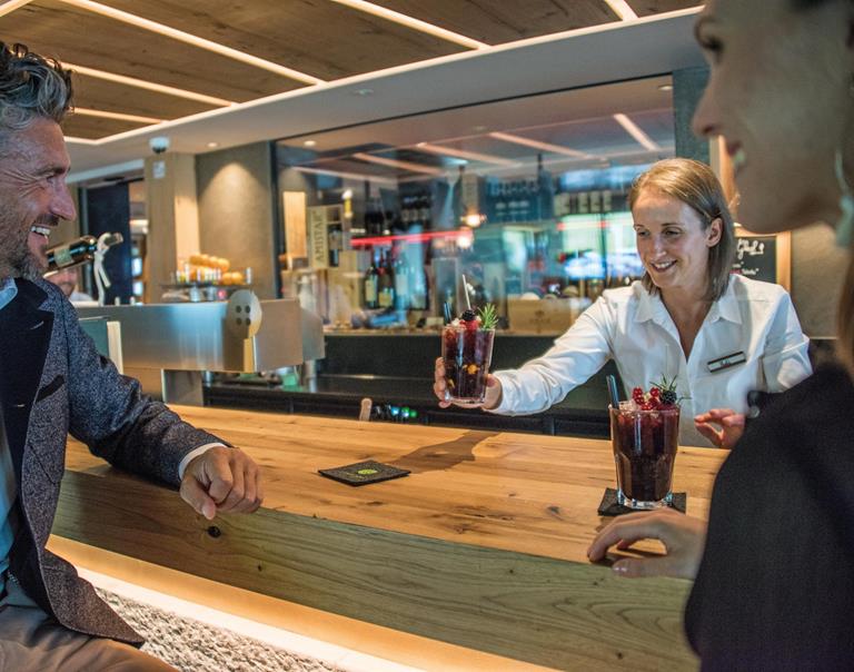 Two guests have cocktails at the bar counter