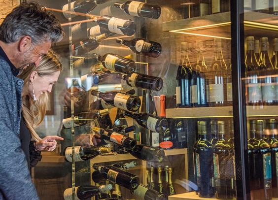 Two guests looking at the wine shelf