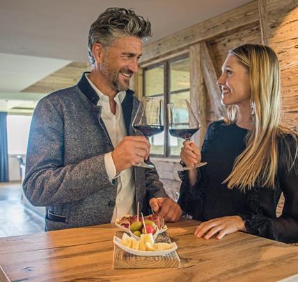 Two guests clink glasses of red wine