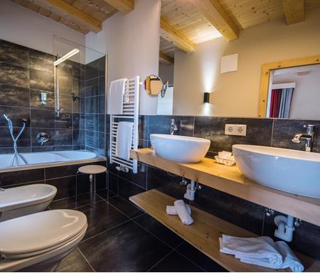 Badezimmer mit Badewanne, WC, Bidet und zwei Waschbecken - Junior Suite