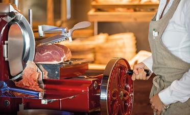 A member of the staff slices ham